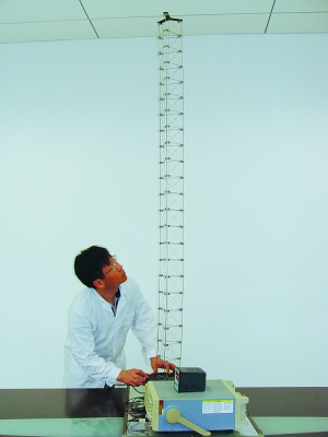 這是伸展開(kāi)的衛星太陽(yáng)能電池用盤(pán)壓伸桿，20厘米長(cháng)螺旋狀的盤(pán)壓伸桿（右側小圖）打開(kāi)后能達2米長(cháng)（8月7日攝）。（新華社發(fā)）