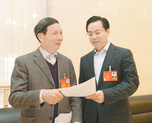 黃伯云代表（左）與劉國忠代表商討完善《關(guān)于建立戰略性新興產(chǎn)業(yè)國家創(chuàng  )新平臺》的建議。 本報記者 張目 攝